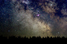 Střed Galaxie vychází nad lesem